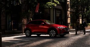 The 2019 Mazda CX-3 in red driving on the streets of Wichita, KS.