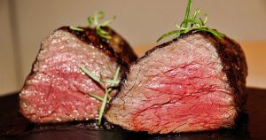 A cut of tenderloin steak with garnish available from a steakhouse in Wichita, KS